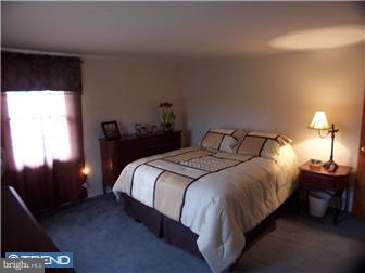23 Tweed Road Levittown, PA 19056 - Photo 11 of 12 a bedroom with a bed and a lamp