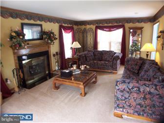 23 Tweed Road Levittown, PA 19056 - Photo 5 of 12 a living room with furniture a flat screen tv and a fireplace