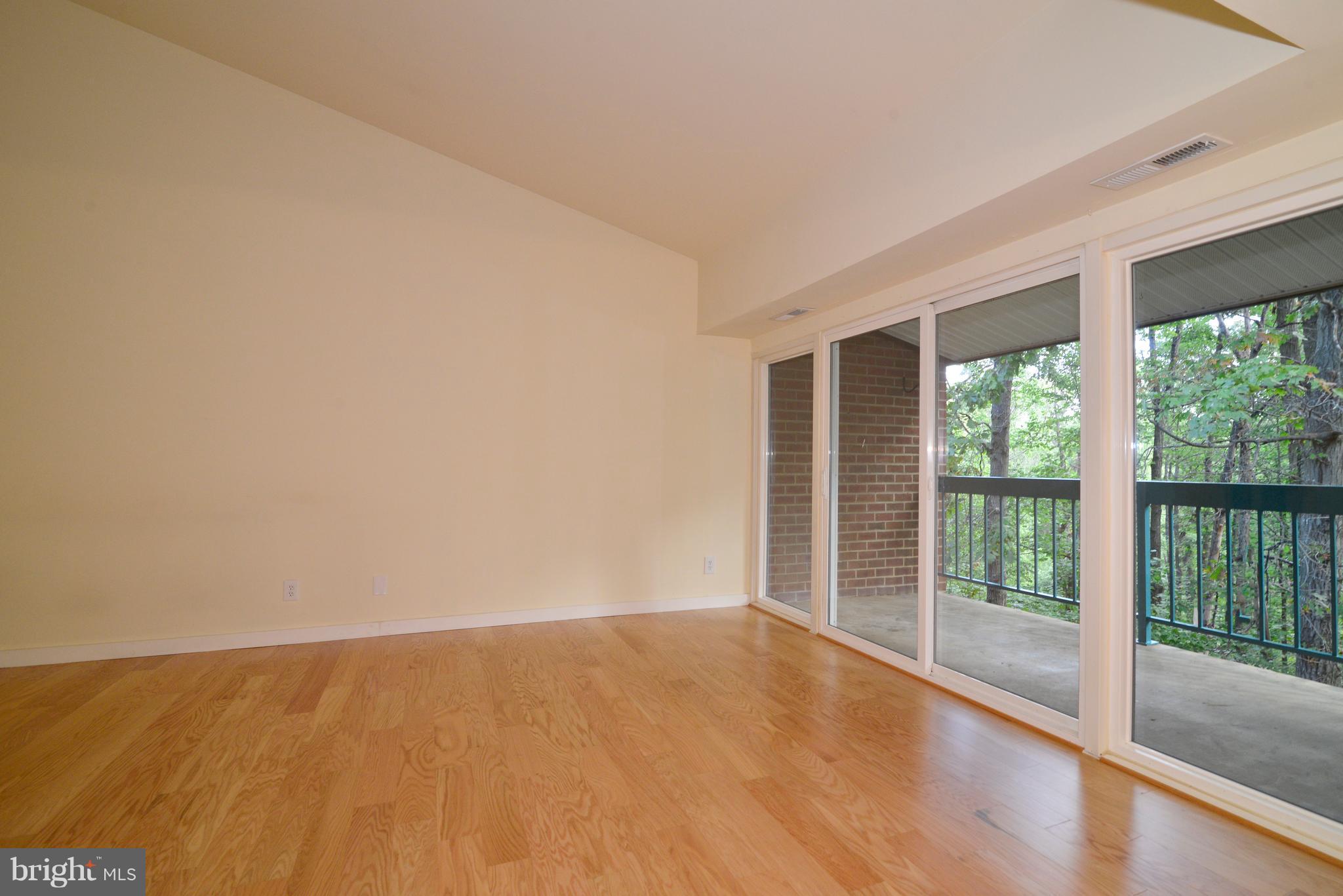 11803 Breton Court, Unit 32C Reston, VA 20191 - Photo 6 of 23 a view of an empty room with wooden floor and a window