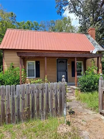 a view of a house with a small yard and wooden fence