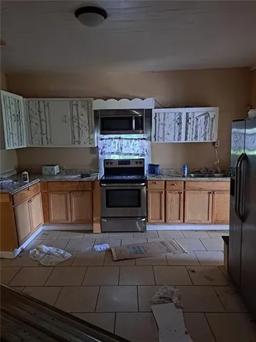 a kitchen with kitchen island granite countertop a stove top oven and cabinets