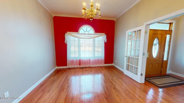 en empty room with wooden floor and fan