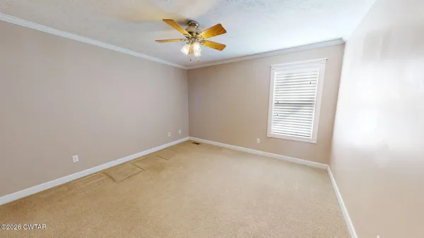an empty room with windows and fan