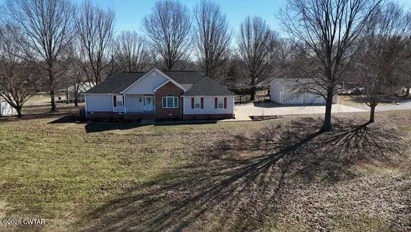a front view of a house with a yard covered in snow