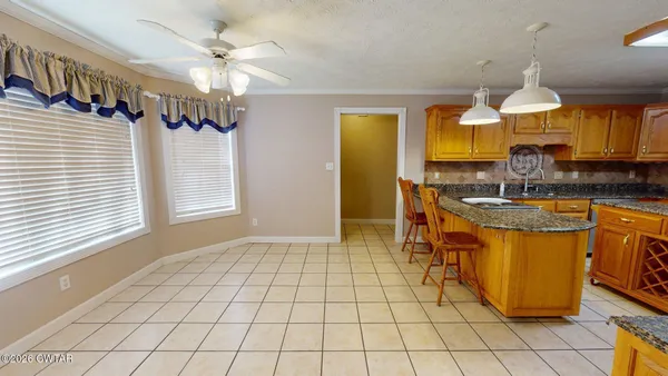 a kitchen with stainless steel appliances a stove a sink cabinets and a dining table