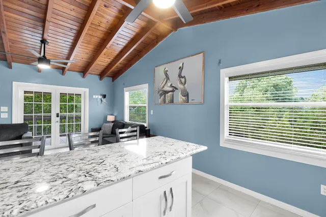 a living room with furniture a flat screen tv and floor to ceiling window