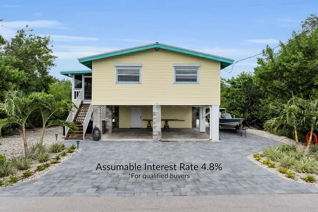 a view of a house with a patio and a yard