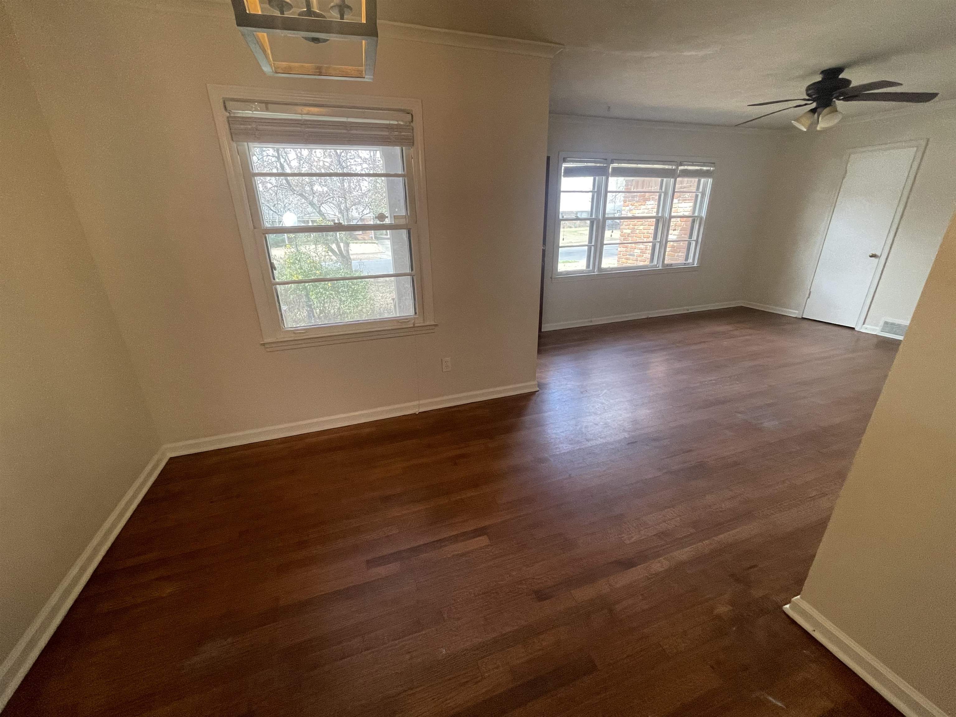 1626 Wheaton Street Memphis, TN 38117 - Photo 11 of 12 an empty room with wooden floor and windows
