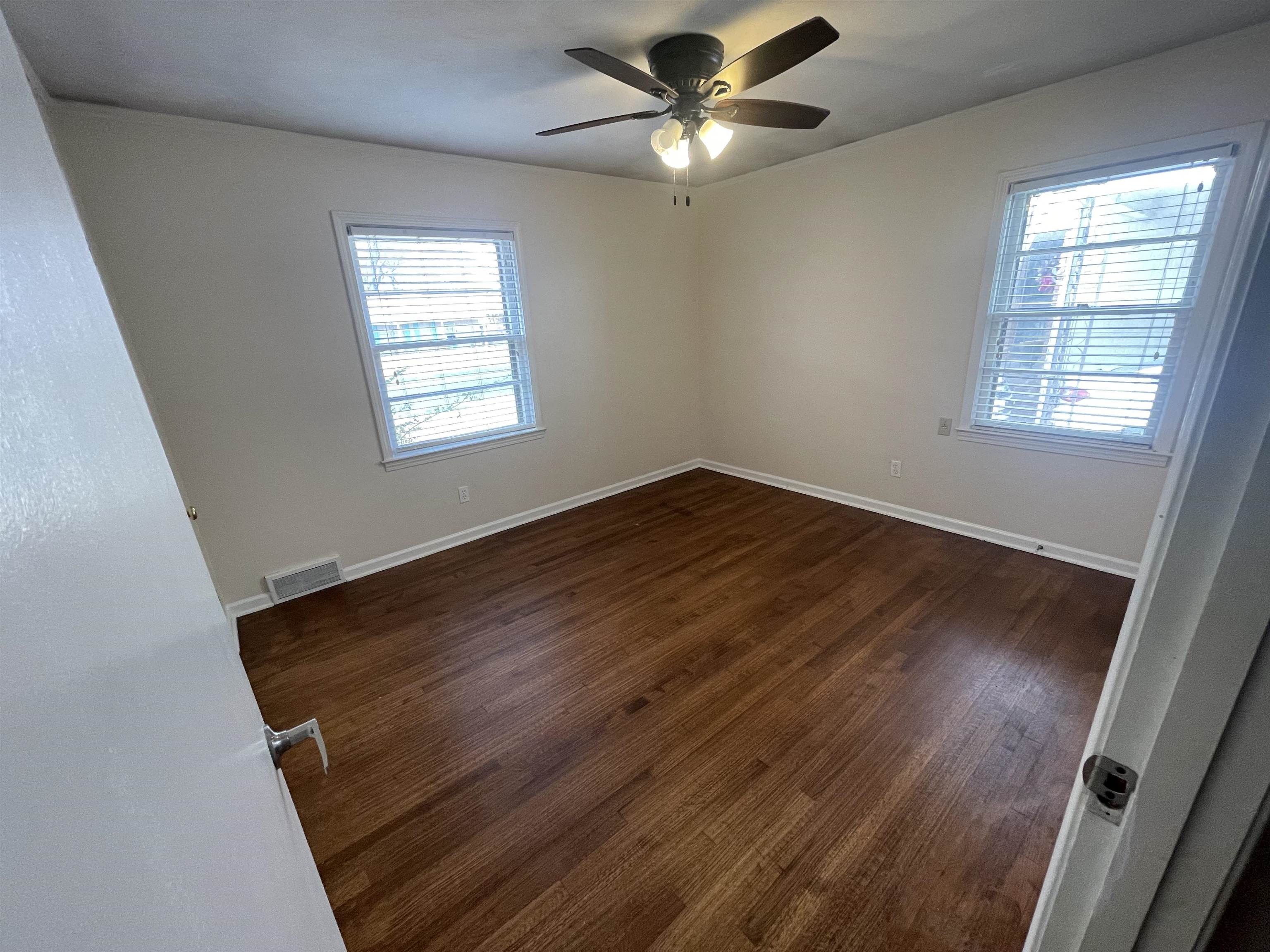 1626 Wheaton Street Memphis, TN 38117 - Photo 12 of 12 a view of an empty room with wooden floor and a window