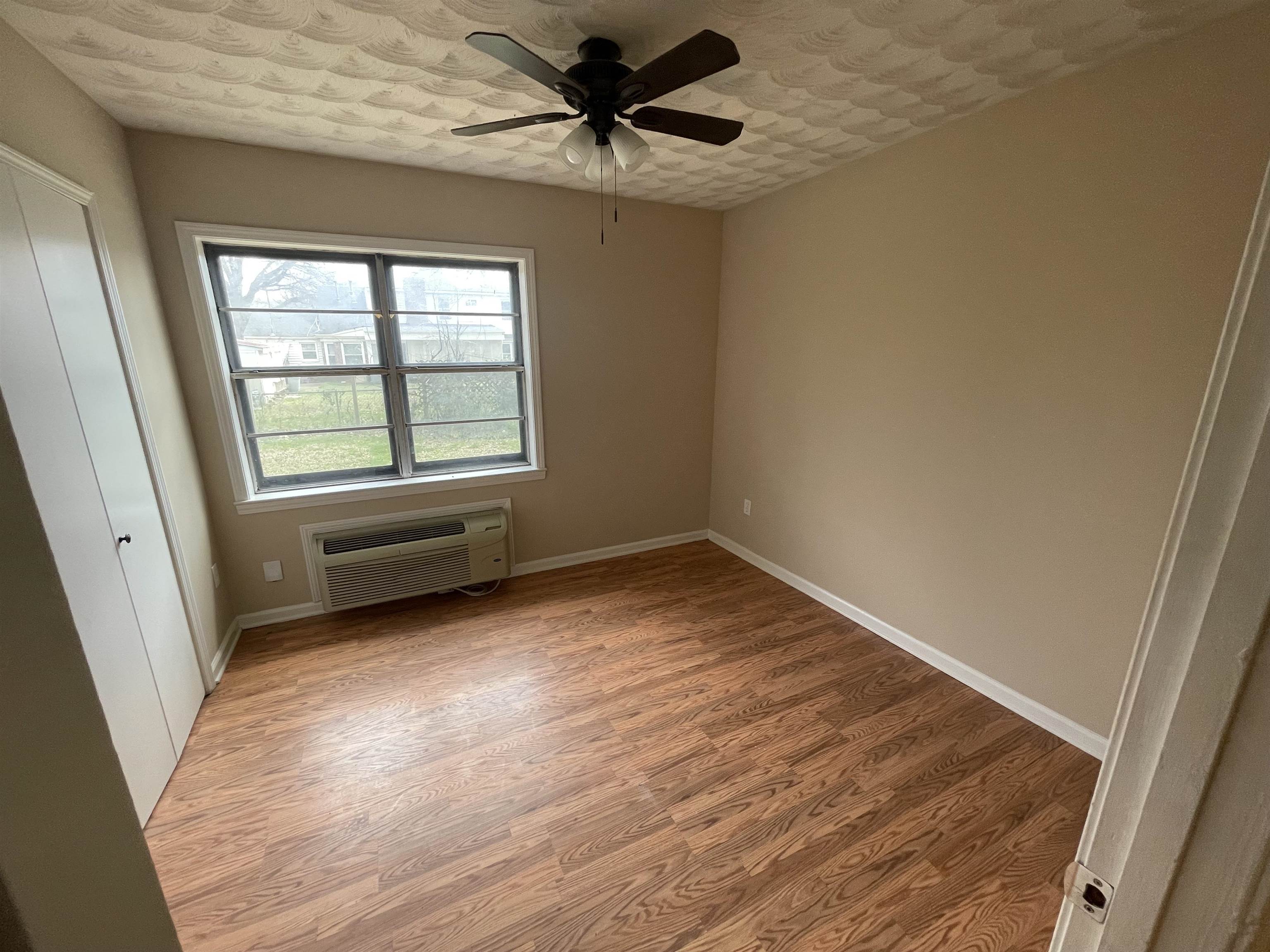 1626 Wheaton Street Memphis, TN 38117 - Photo 8 of 12 wooden floor in an empty room with a window
