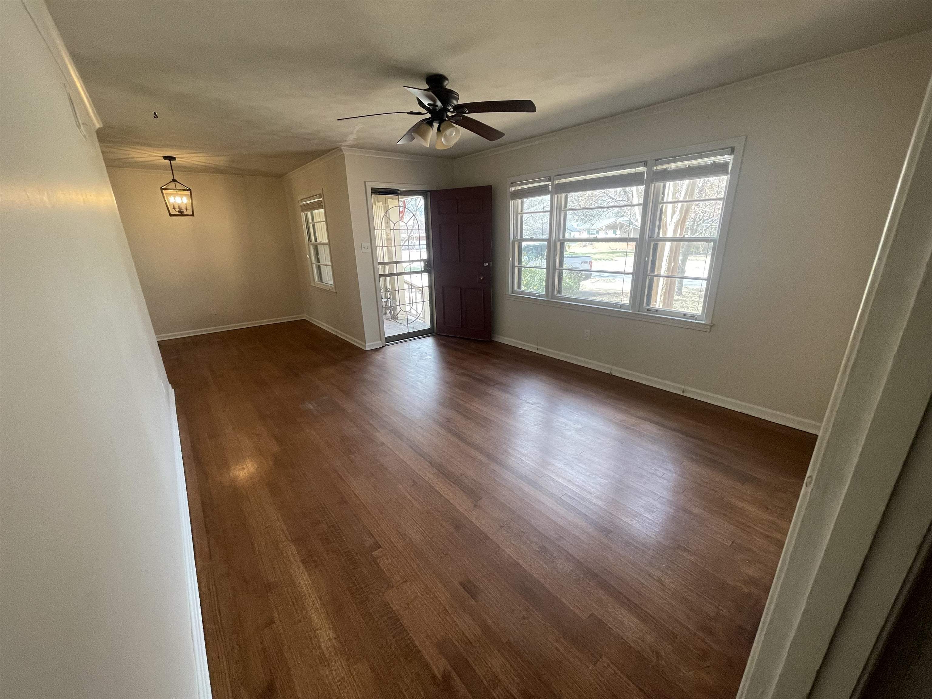 1626 Wheaton Street Memphis, TN 38117 - Photo 10 of 12 an empty room with wooden floor and windows