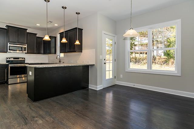 3501 Bloomfield Way Raleigh, NC 27616 - Photo 8 of 25 a kitchen with stainless steel appliances granite countertop a stove and a wooden floor