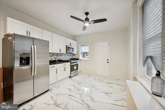 a kitchen with stainless steel appliances a refrigerator sink and cabinets