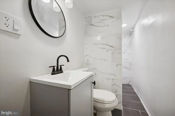 a bathroom with a sink a toilet and a mirror