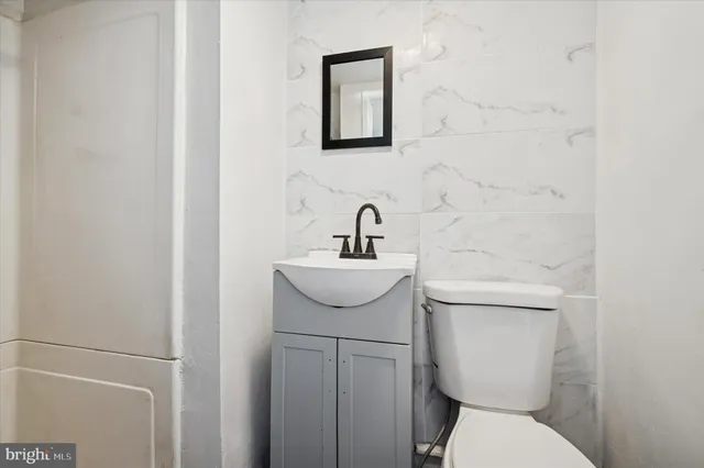 a bathroom with a toilet sink and mirror