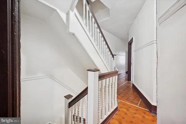 a view of staircase with railing and white walls