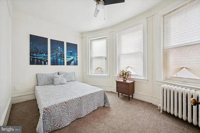 a bedroom with a bed and a table chair