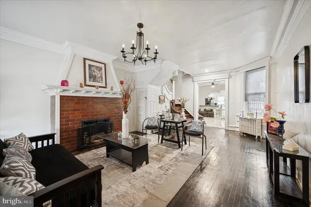 a living room with furniture dining table a fireplace and a window
