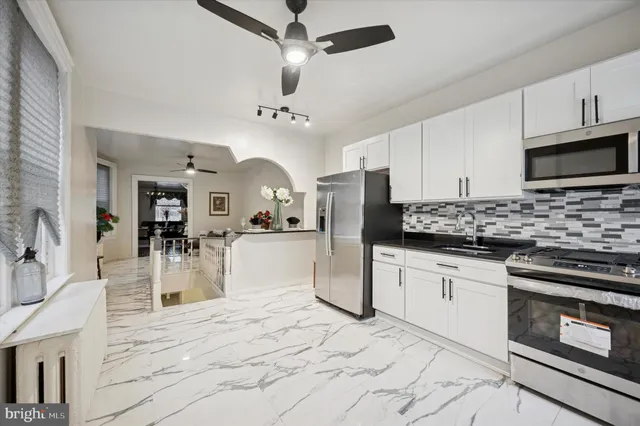 a kitchen with stainless steel appliances kitchen island granite countertop a stove sink and microwave