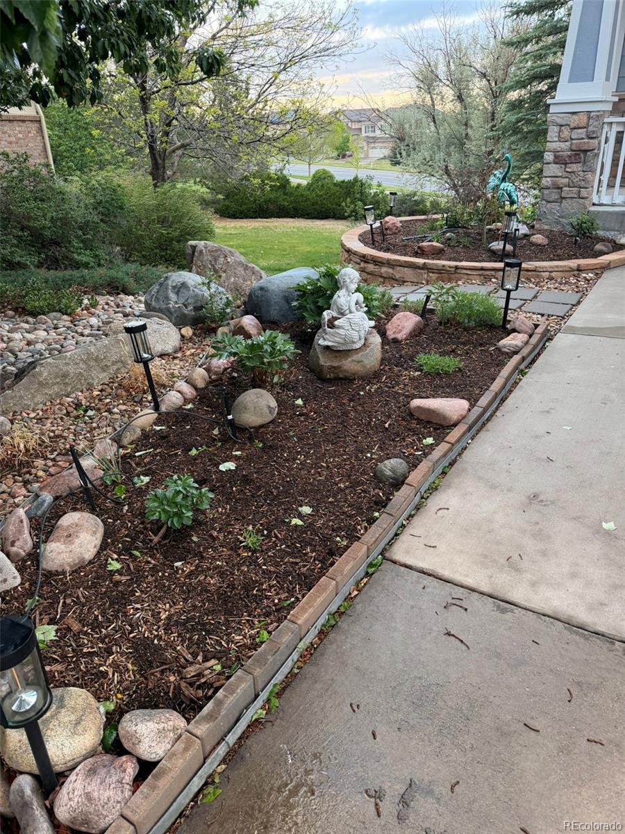 7242 South Rome Street Aurora, CO 80016 - Photo 27 of 33 a view of a backyard with plants and a bench
