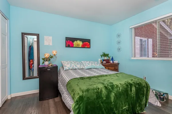 a bedroom with a bed and a potted plant