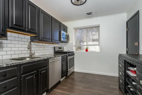 a kitchen with stainless steel appliances granite countertop a sink stove and microwave