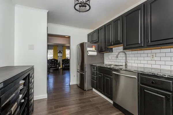 a kitchen with stainless steel appliances granite countertop a sink stove and refrigerator