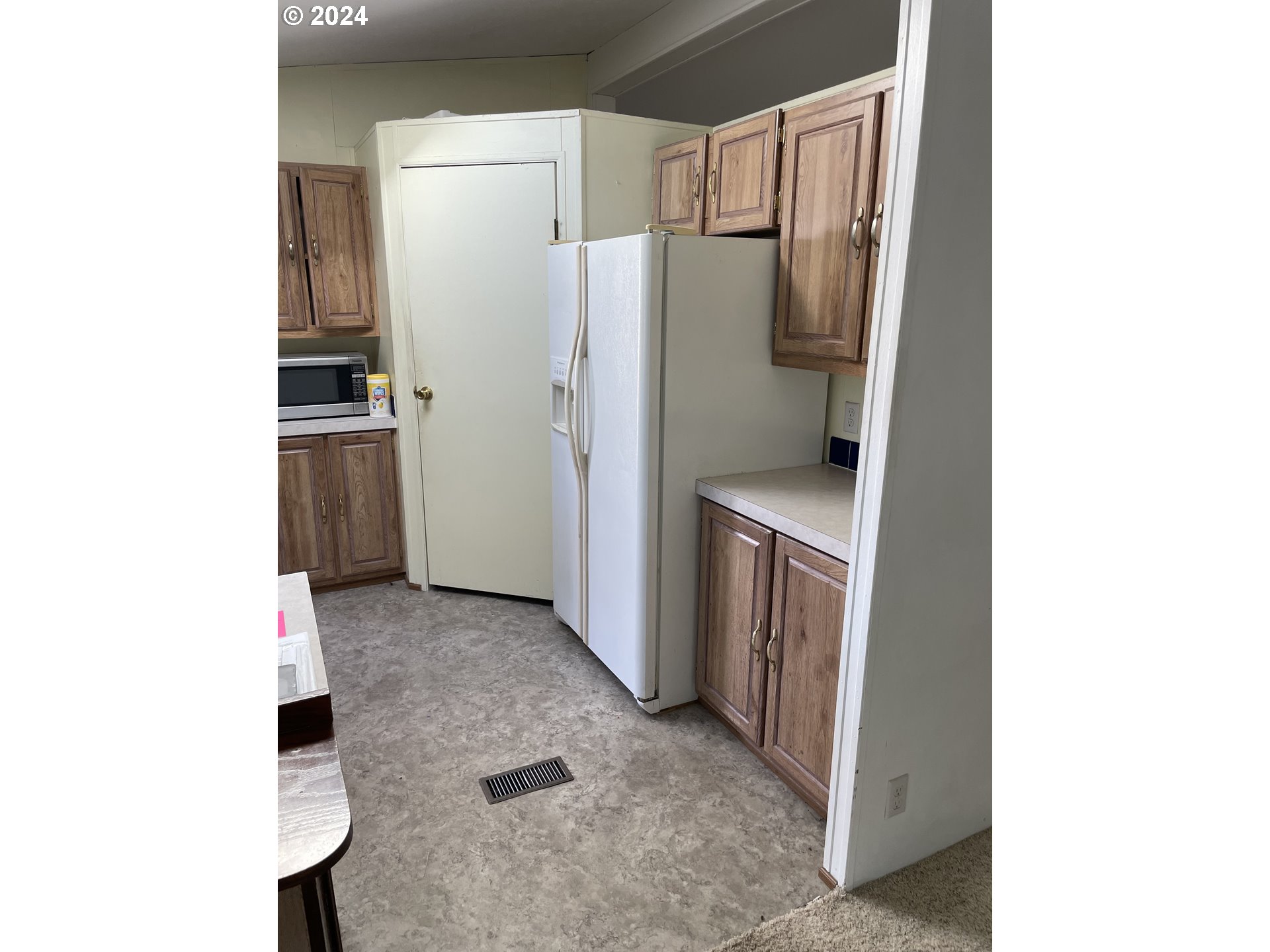 55096 Harrison Road Southwest Bandon, OR 97411 - Photo 12 of 34 a kitchen with a refrigerator and a stove