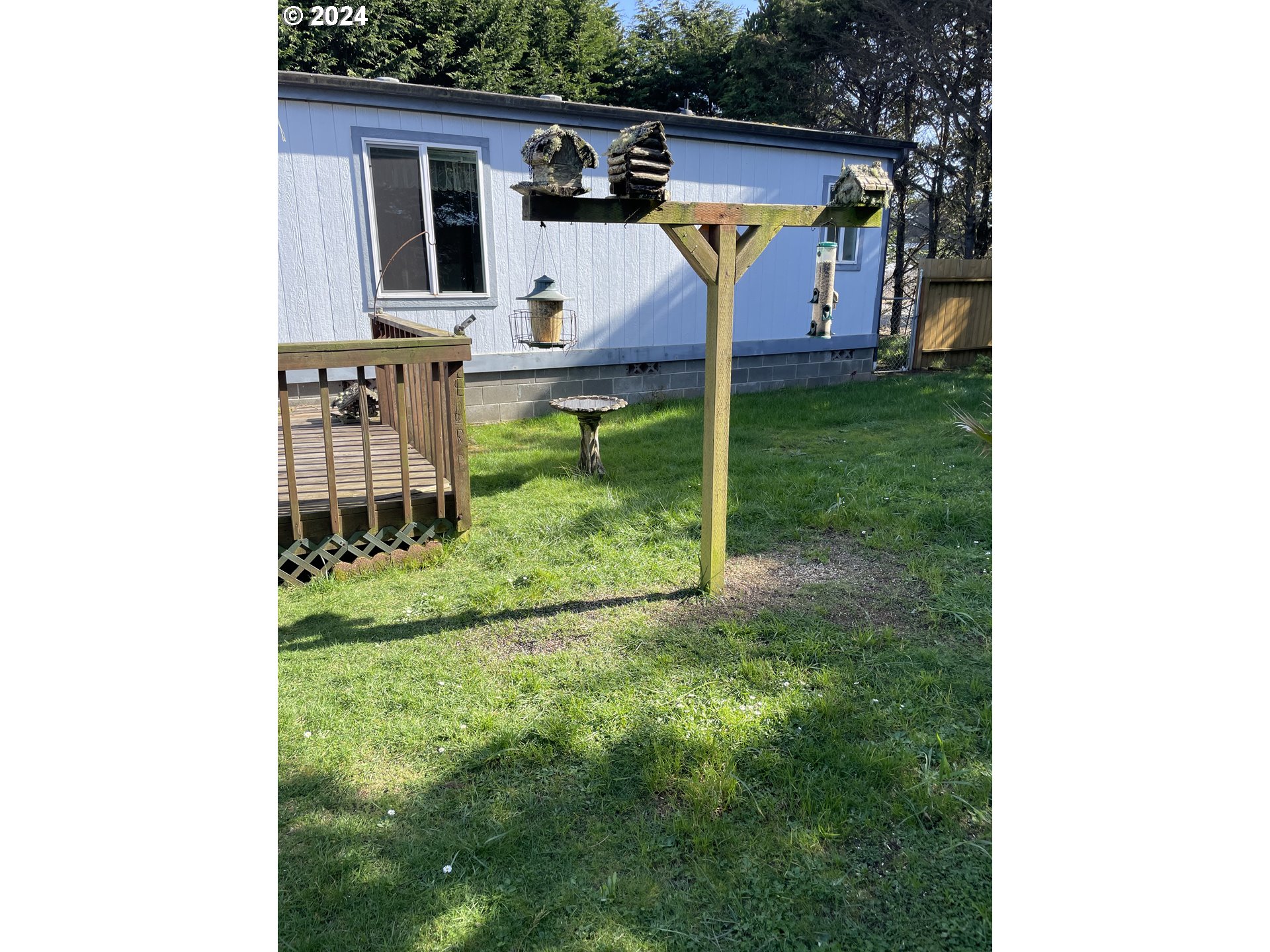 55096 Harrison Road Southwest Bandon, OR 97411 - Photo 29 of 34 a view of a backyard with table and chairs and potted plants