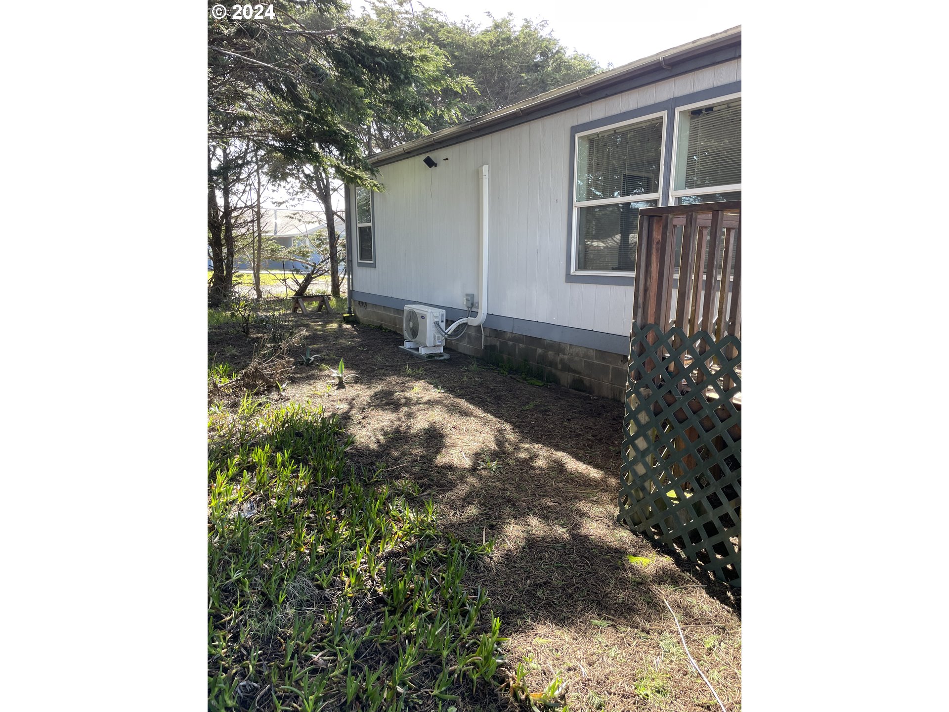 55096 Harrison Road Southwest Bandon, OR 97411 - Photo 3 of 34 a backyard of a house with table and chairs
