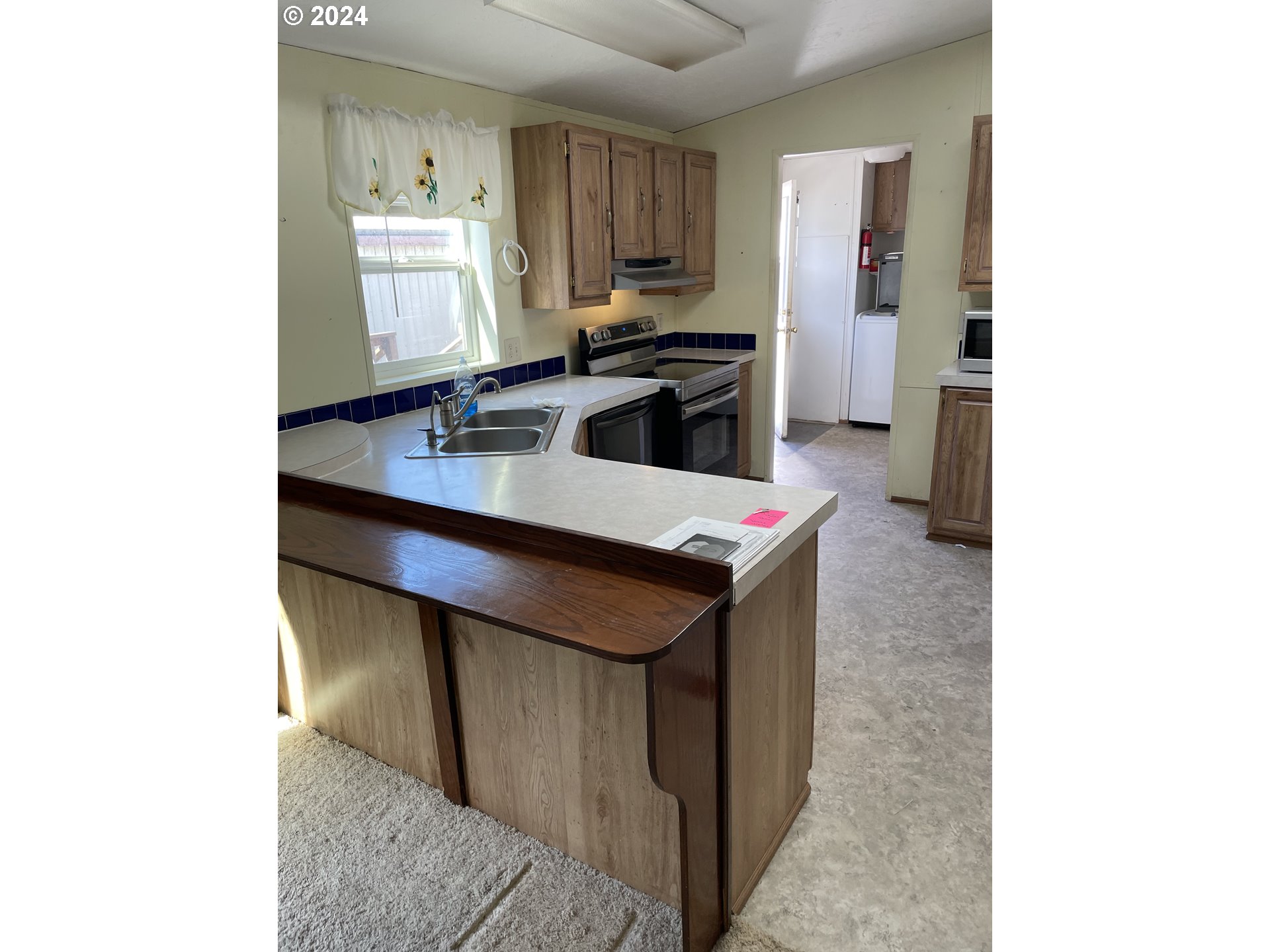 55096 Harrison Road Southwest Bandon, OR 97411 - Photo 10 of 34 a kitchen with a sink cabinets and a window