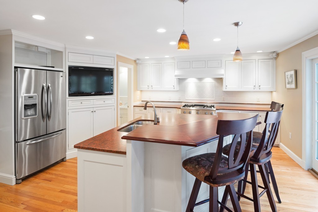 21 Fairway Road Brookline, MA 02467 - Photo 7 of 30 a kitchen with stainless steel appliances granite countertop a sink a microwave and wooden cabinets