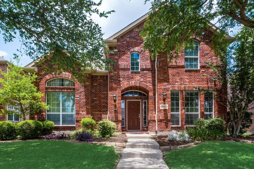 front view of a brick house with a yard