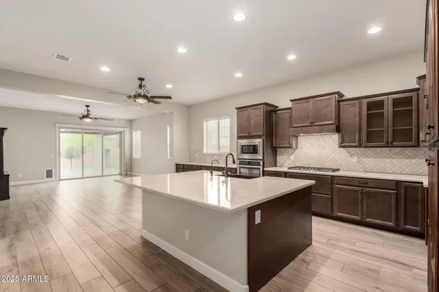 a large kitchen with stainless steel appliances granite countertop a sink and a stove