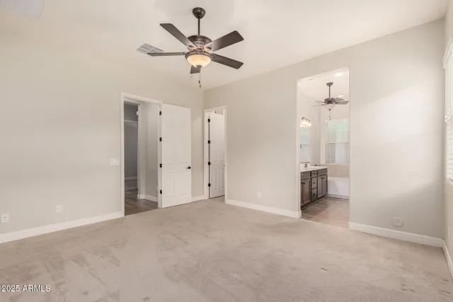 an empty room with a ceiling fan and a window