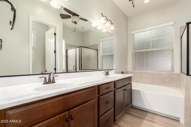 a bathroom with a double vanity sink a mirror and a bathtub