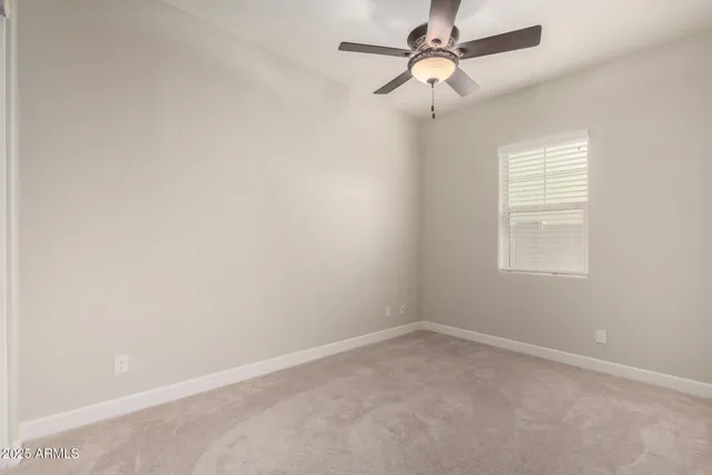 an empty room with a window and a fan