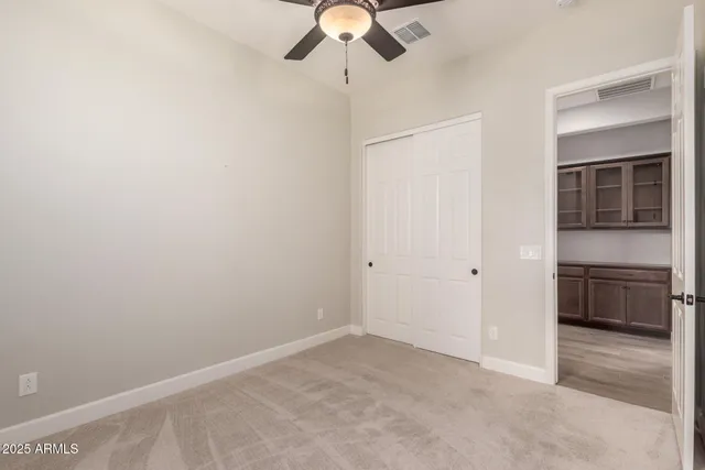 a view of an empty room with a ceiling fan
