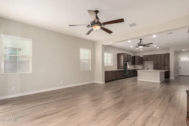 a view of a living room a ceiling fan and wooden floor