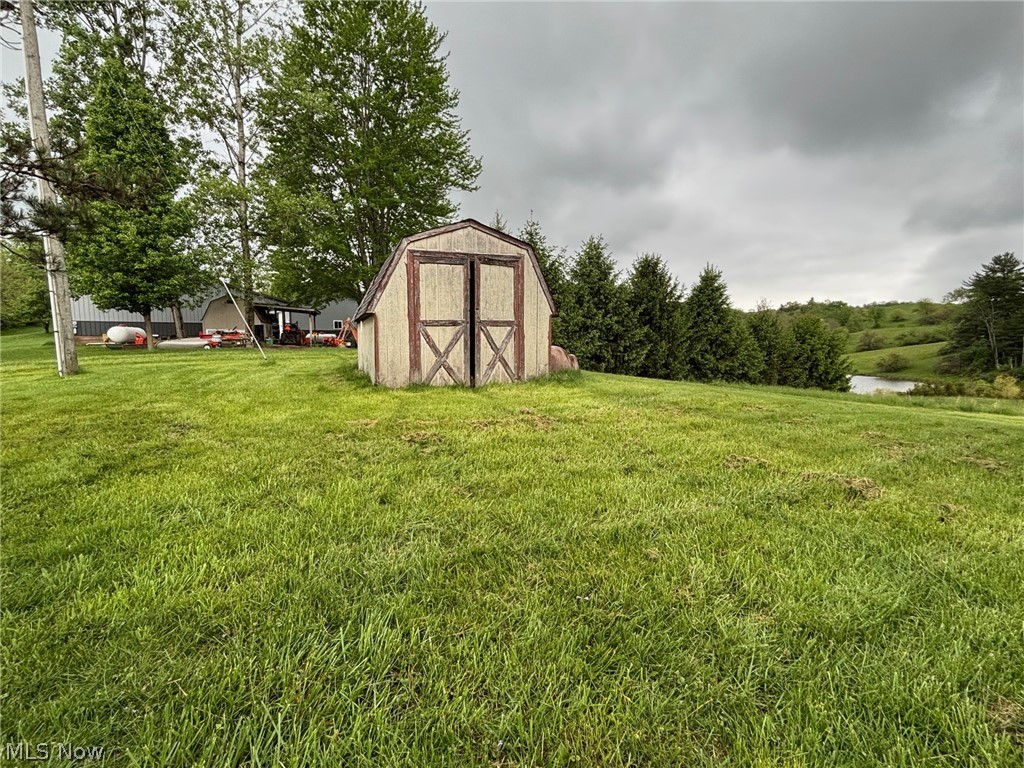 57575 Marietta Road Byesville, OH 43723 - Photo 25 of 25 Detached storage shed with double barn doors, set on a verdant grassy expanse
