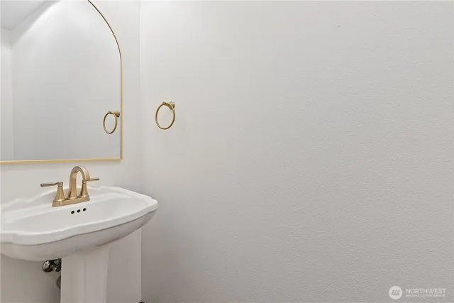 a bathroom with a sink and mirror with shower