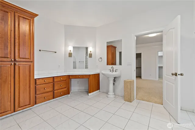 a spacious bathroom with a double vanity sink a mirror and a bathtub