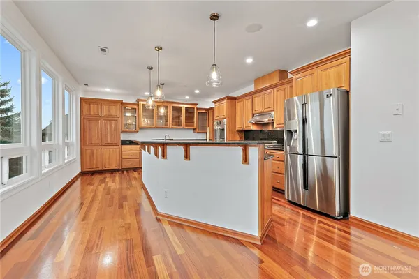 a kitchen with granite countertop a sink a counter space appliances and cabinets