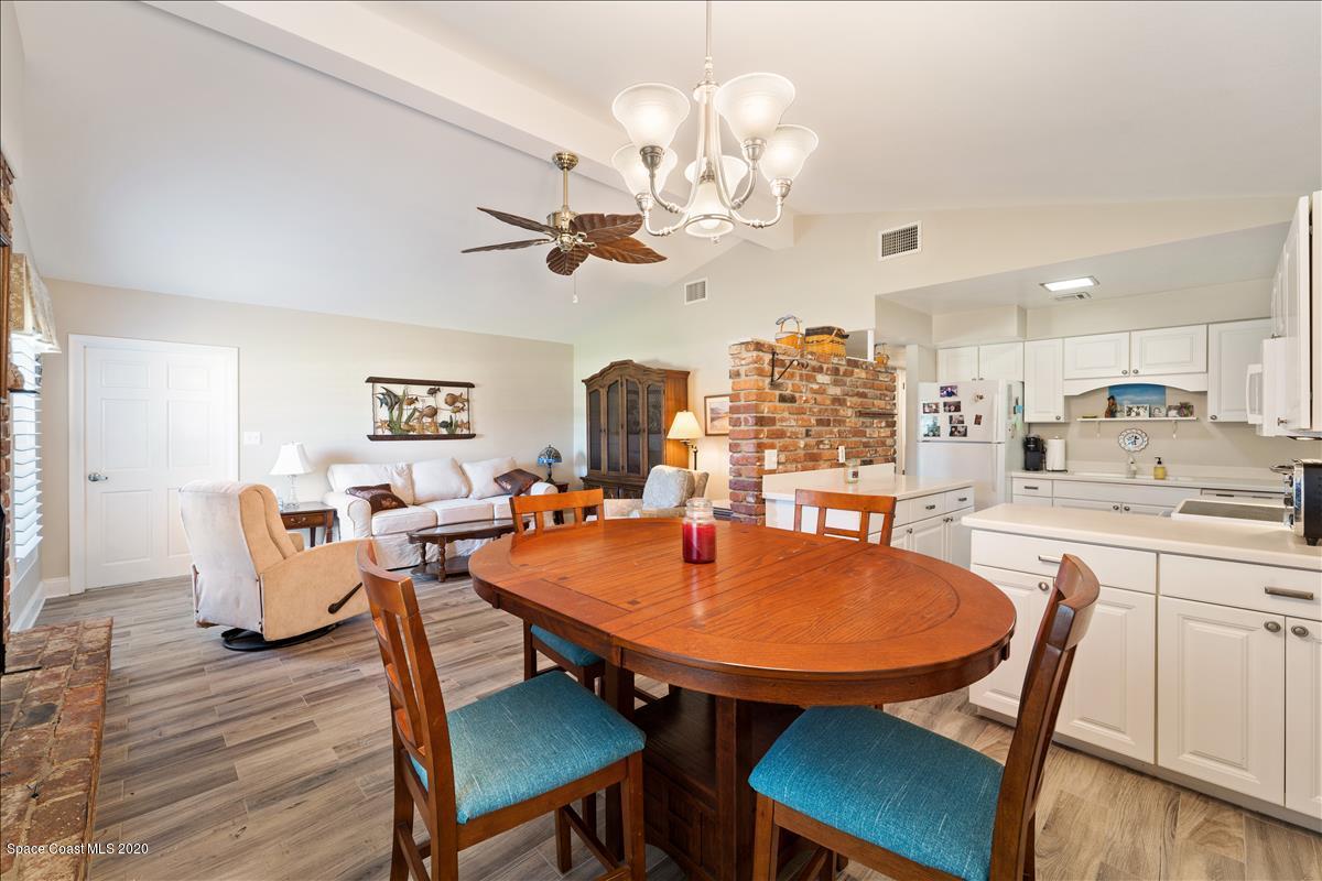 650 Java Road Cocoa Beach, FL 32931 - Photo 22 of 39 a view of a dining room with furniture a chandelier and wooden floor