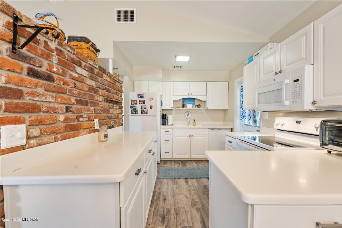 650 Java Road Cocoa Beach, FL 32931 - Photo 24 of 39 a kitchen with stainless steel appliances a sink a stove a refrigerator and cabinets