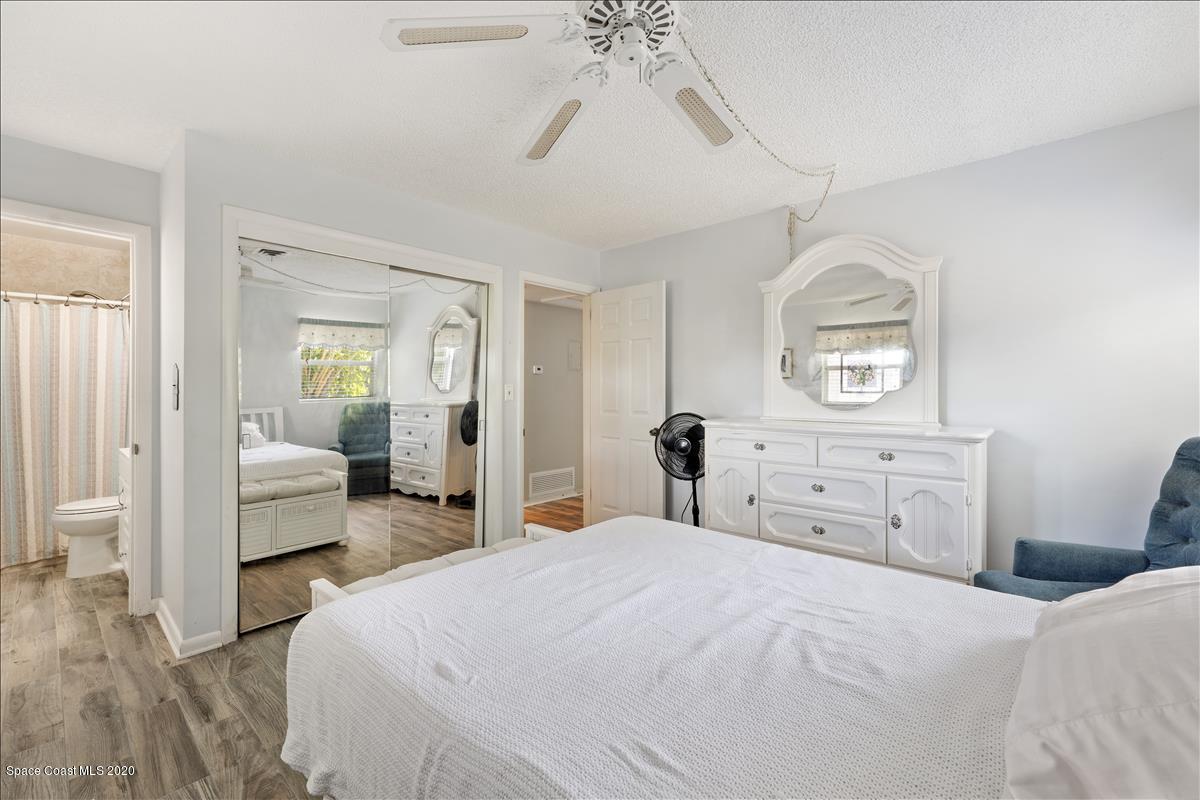 650 Java Road Cocoa Beach, FL 32931 - Photo 29 of 39 a bedroom with a bed and a chandelier