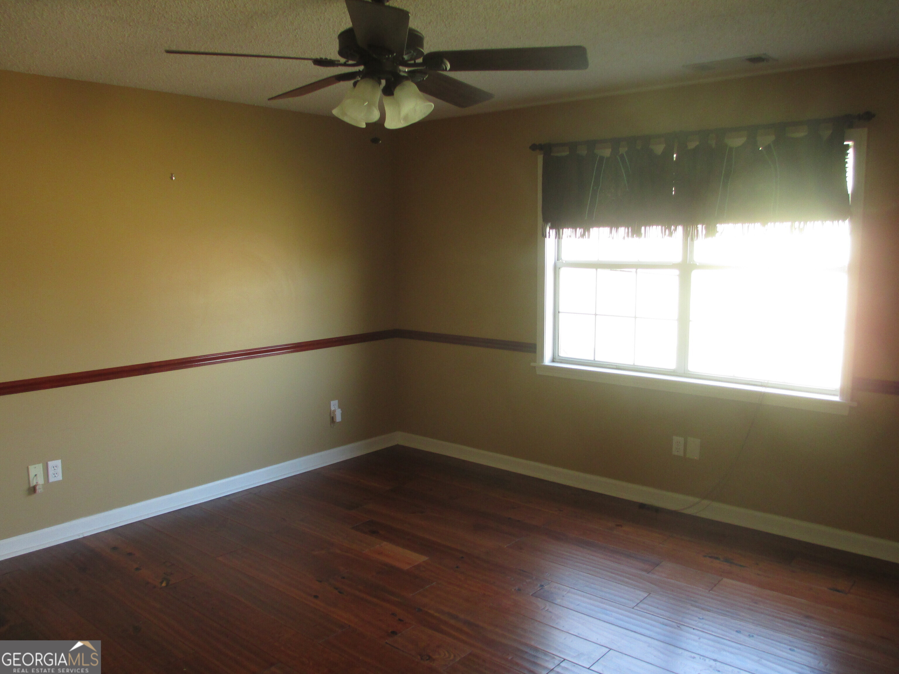 4262 Highway 15 Vidalia, GA 30474 - Photo 76 of 79 an empty room with wooden floor and windows