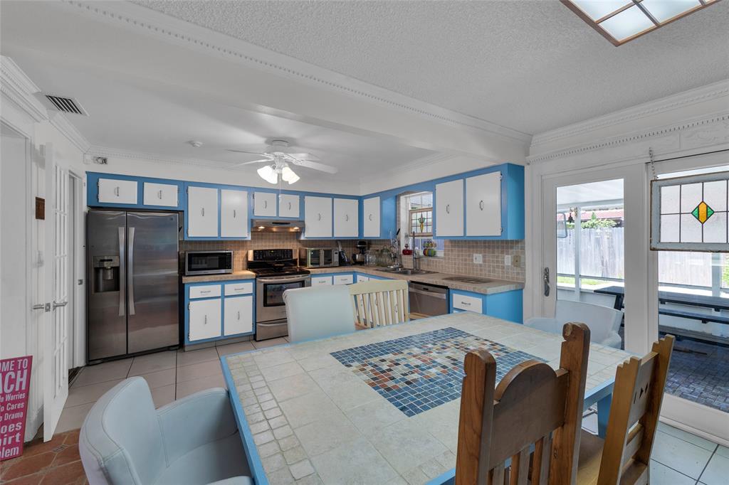 3213 Dover Road Pompano Beach, FL 33062 - Photo 40 of 53 a kitchen with refrigerator cabinets dining table and chairs