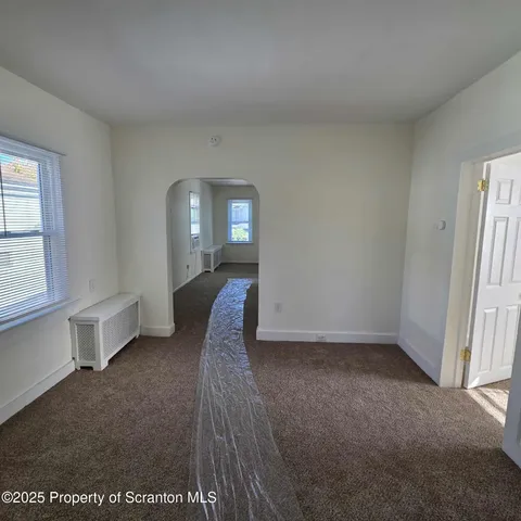 a view of a livingroom with wooden floor and cabinet