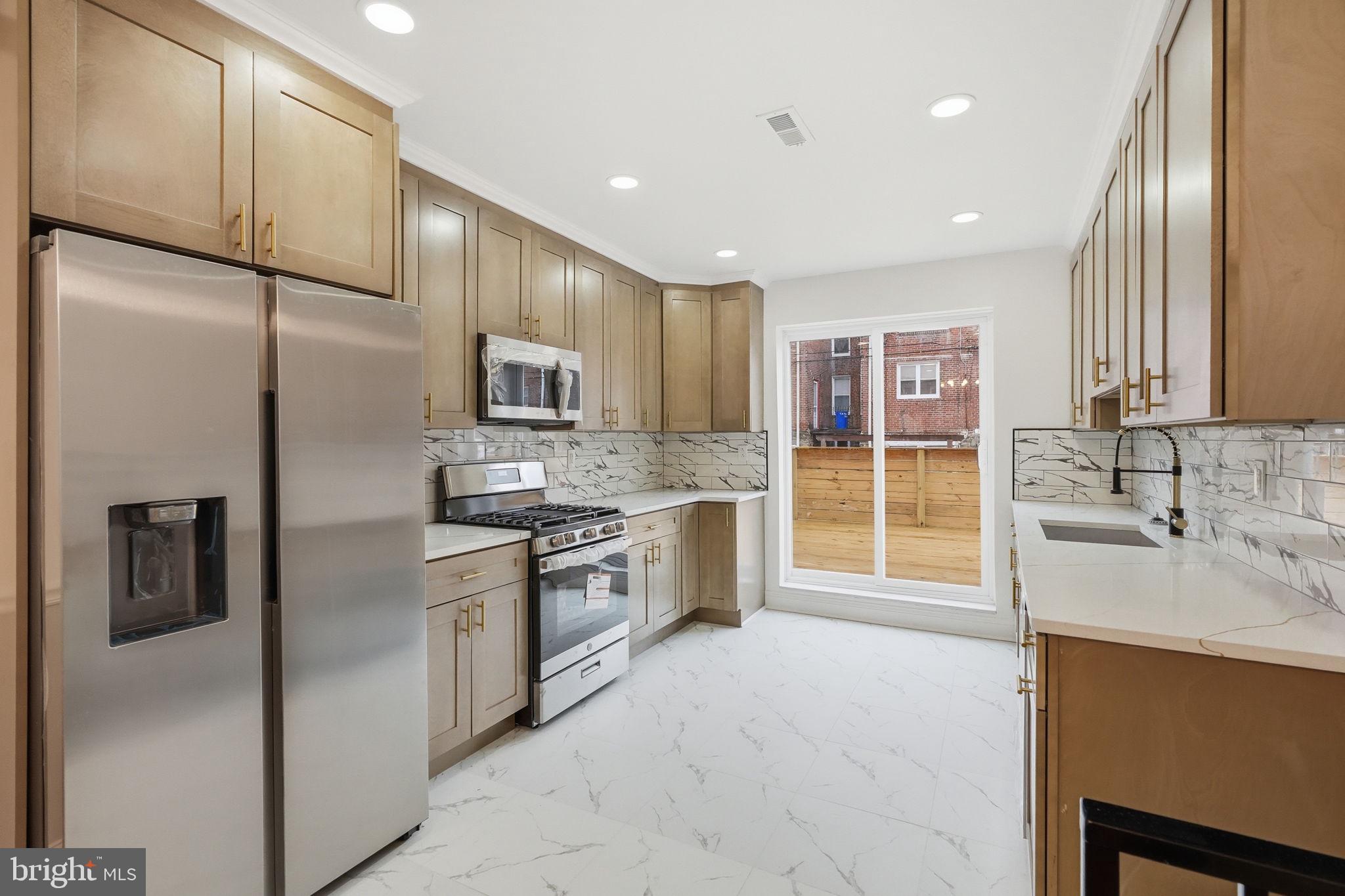 7413 Sommers Road Philadelphia, PA 19138 - Photo 11 of 54 a kitchen with stainless steel appliances granite countertop a refrigerator a sink a stove and oven